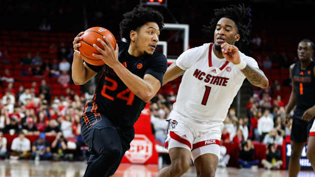 Miami's Nijel Pack drives versus NC State's Jayden Taylor